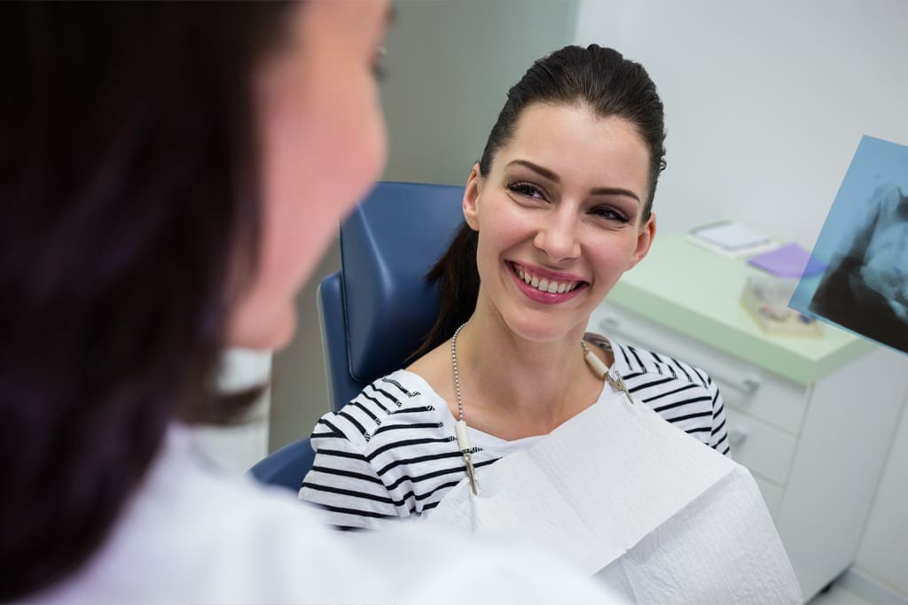 female patient smiling while talking doctor
