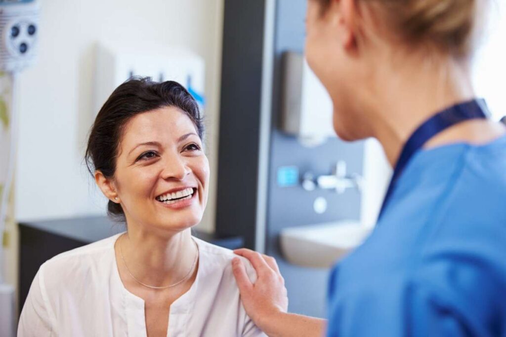 Dentist reassuring a smiling patient during an IV sedation dentistry consultation in a dental clinic