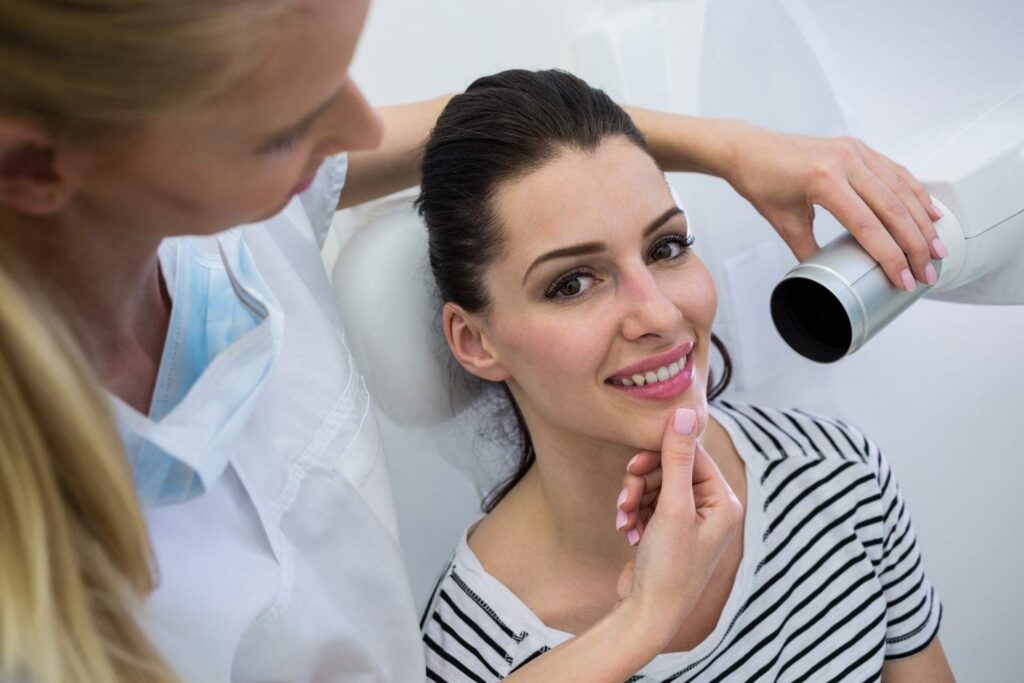 Dentist examining patient’s smile during dental appointment.
