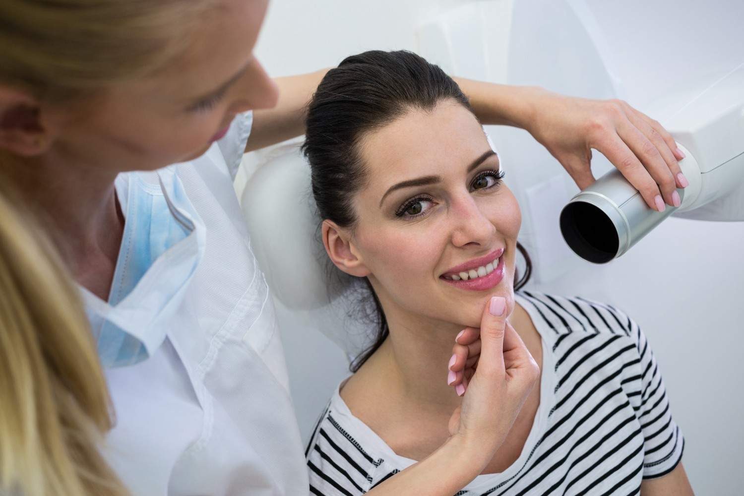 Dentist examining patient’s smile during dental appointment.