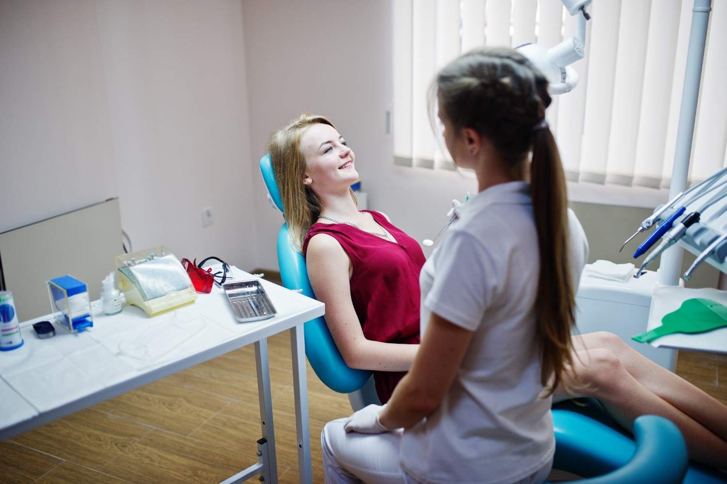 Patient speaking with dental hygienist during routine dental visit.