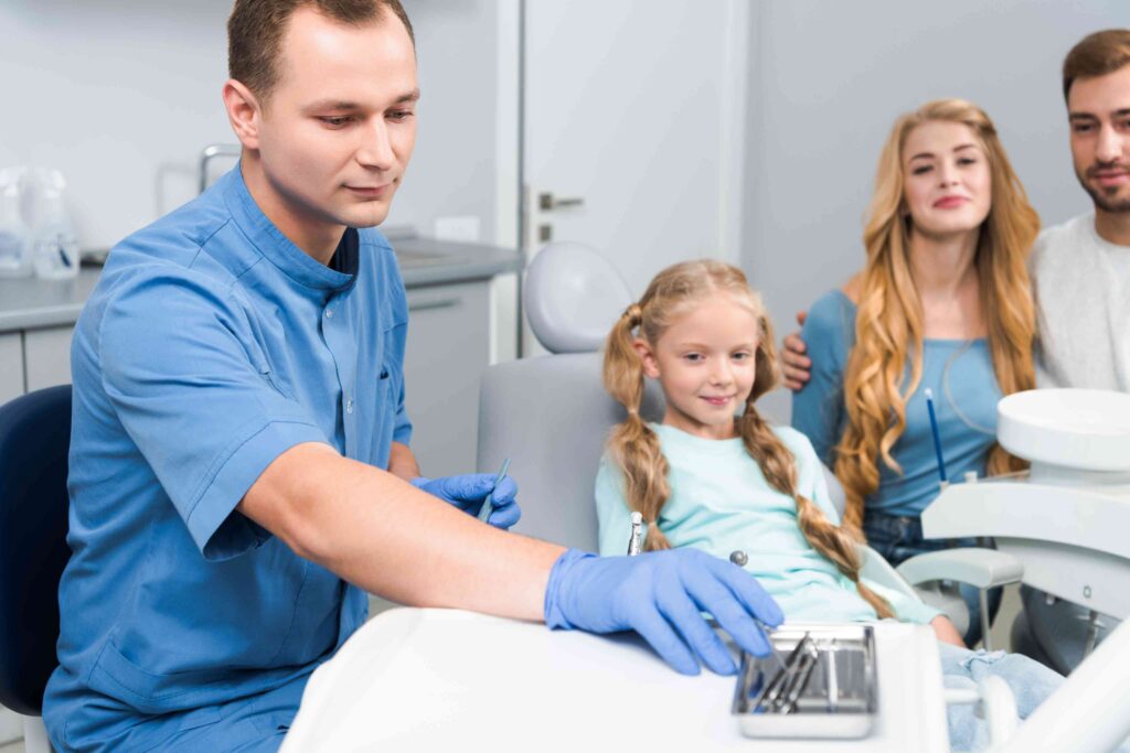Child visiting a dentist with her parents.